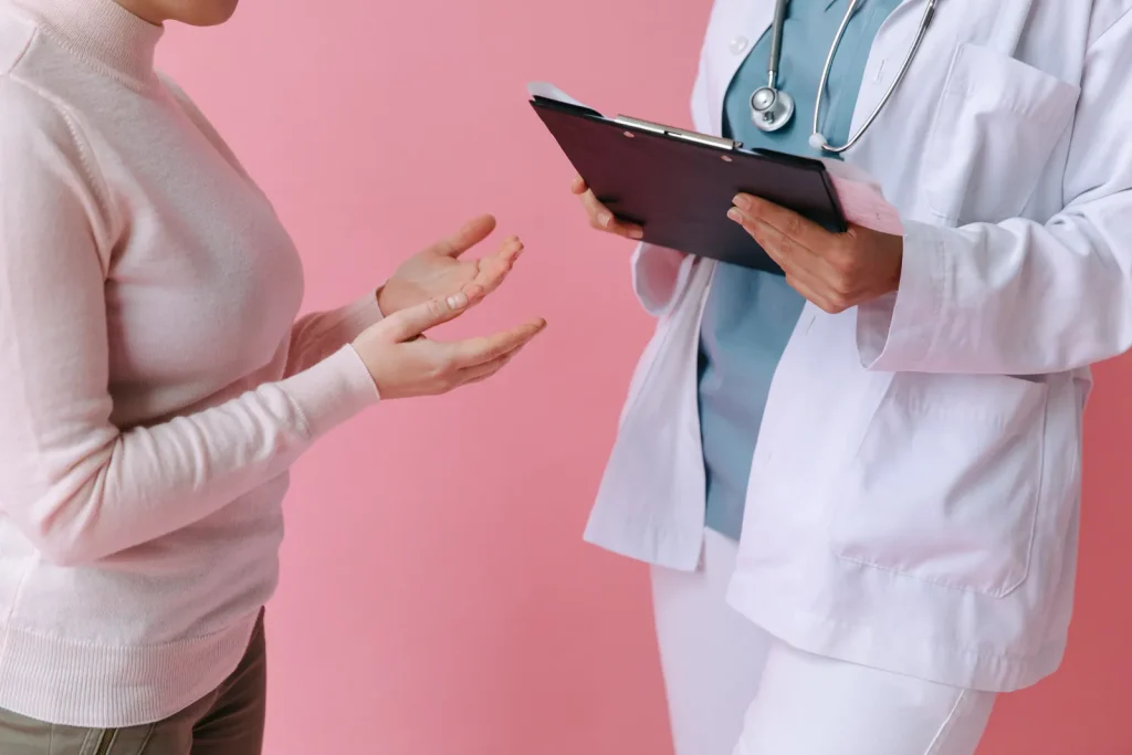 Una paciente conversa con una médica que sostiene una tableta, sin mostrar sus rostros