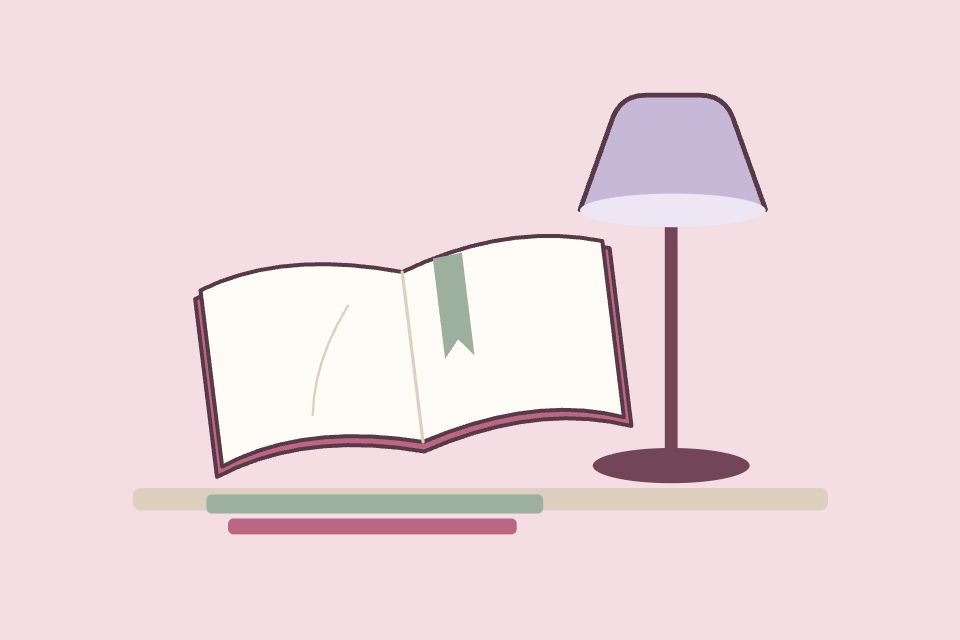 Libro abierto con separador verde, una lámpara lavanda y dos libros apilados.
