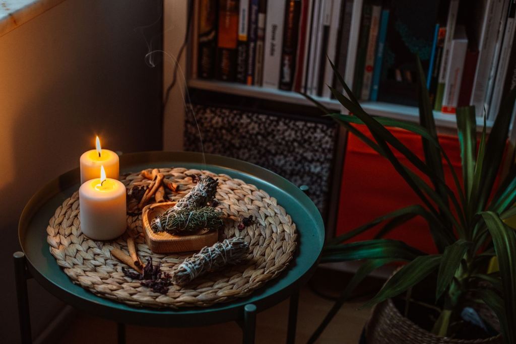 Velas encendidas e incienso sobre una mesa en casa, en un ambiente tranquilo.
