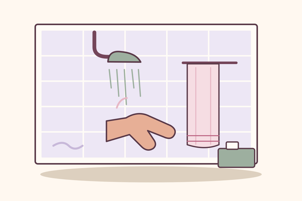 Agua de una ducha, una mano abierta y una toalla sobre una pared de azulejos en tonos suaves.